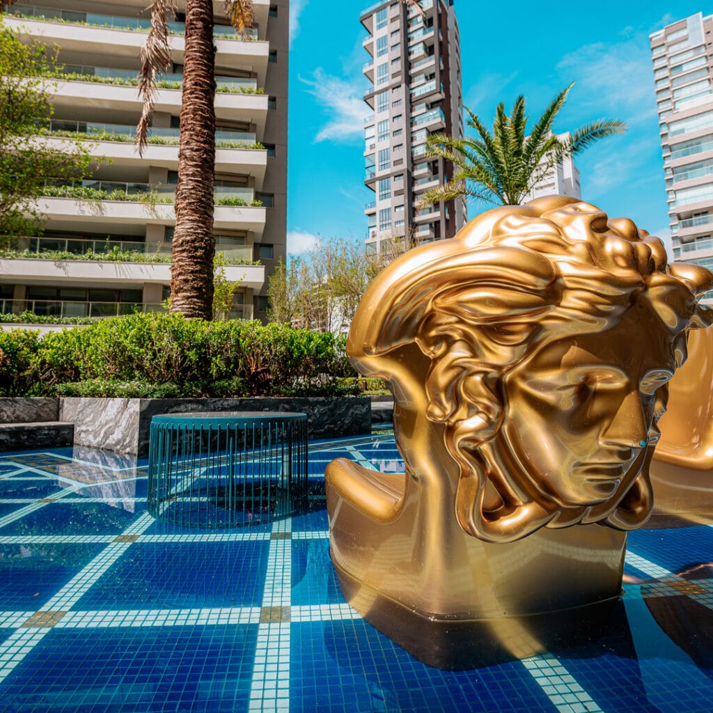 Piscina No Deck Molhado Do Villa Versace Moema Com Poltrona Icônica Em Formato De Rosto, Assinatura Da Marca Versace, No Condomínio Pronto Para Morar Em Moema.