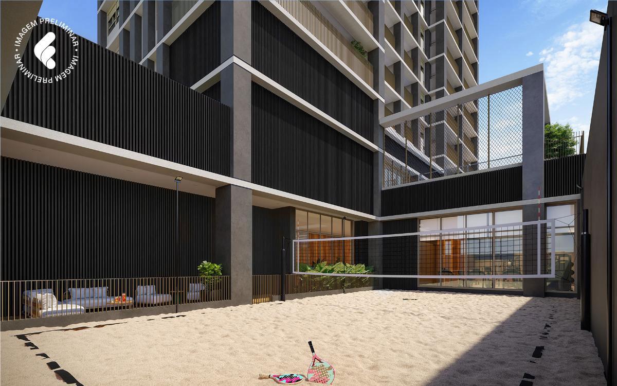 Área esportiva com areia e rede para beach tennis em espaço integrado ao edifício