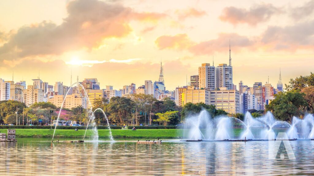 Lago Do Parque Ibirapuera Refletindo O Pôr Do Sol, Com Árvores Ao Redor E O Skyline De São Paulo Ao Fundo