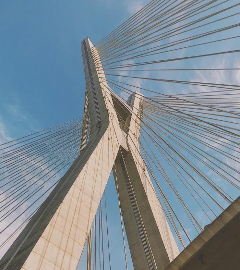 Close-up da estrutura imponente da Ponte Estaiada em São Paulo, com seus cabos e pilares, simbolizando a modernidade e a localização privilegiada do São Paulo Bay Even.