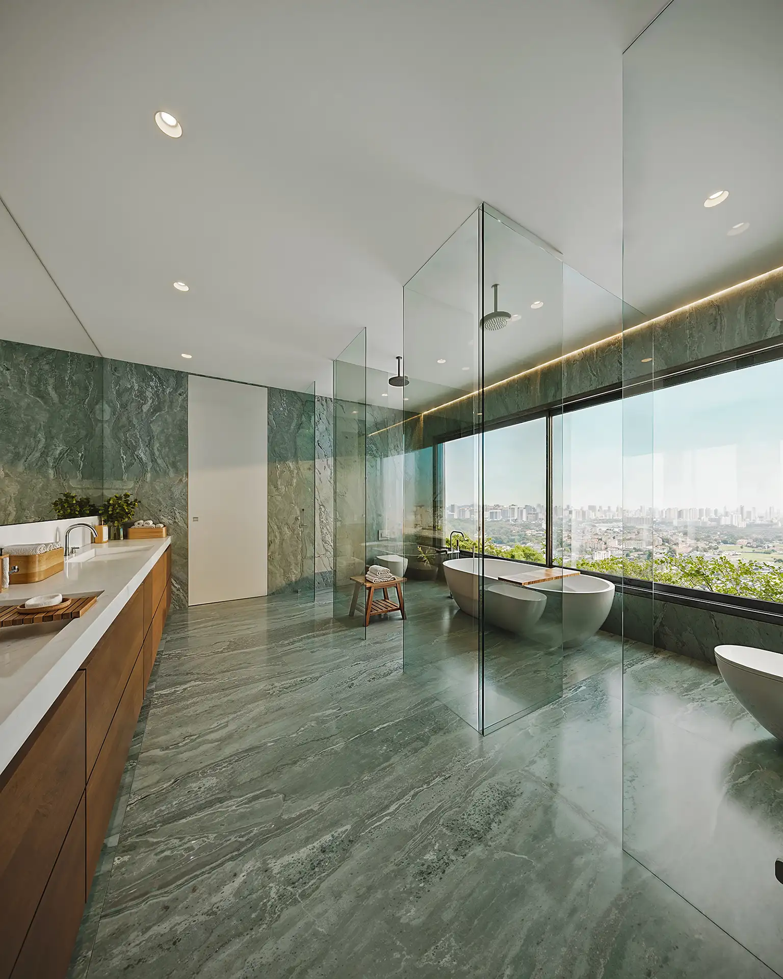 LUX 600 — banheiro da suíte master em mármore verde com banheira e vista da cidade — curadoria iApartamentos — Vila Nova Conceição
