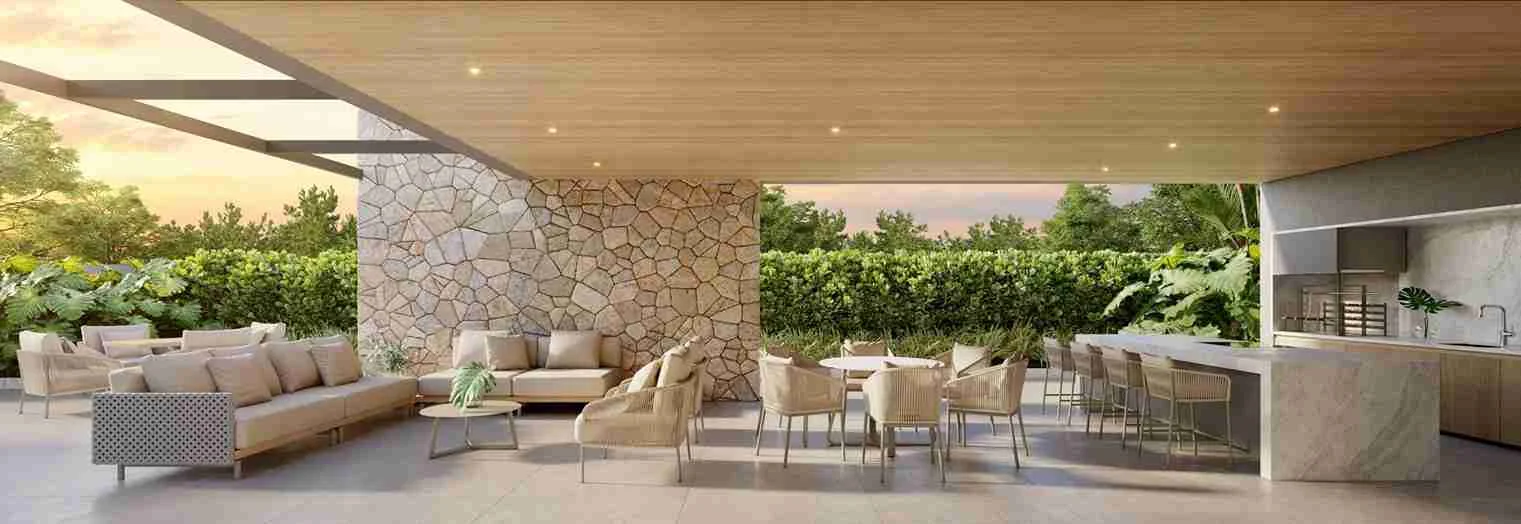 Espaço gourmet com bancada de bar, mesa de jantar, sofás e parede de pedra no Casa Parque Cerâmica