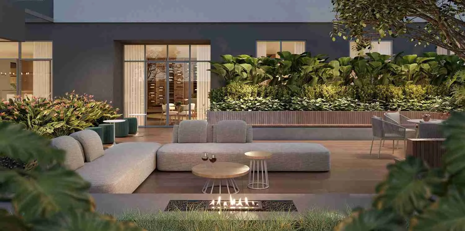 Lounge externo com sofás, mesas de apoio e lareira a gás cercado por jardim no Casa Parque Cerâmica